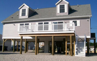 A beach house with a deck and stairs.