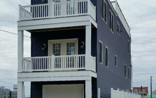 A blue house with white siding and a balcony.