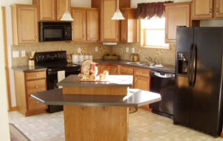 A kitchen with black appliances and wooden cabinets.