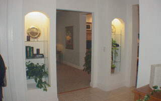 A hallway with a plant on a shelf.