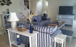 A living room with blue and white striped furniture.