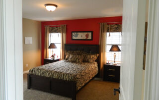 A bedroom with red walls and a zebra print bed.