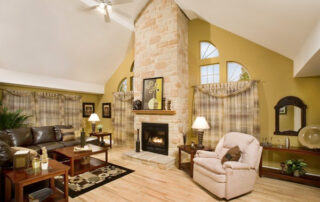 A living room with a stone fireplace.