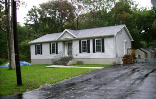 A gray house with a driveway.