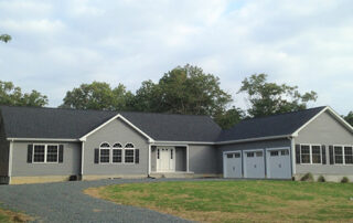 A gray house with two garages.