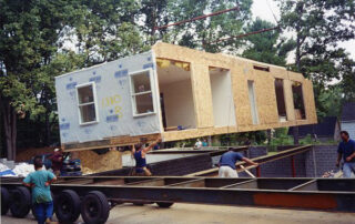 A man lifting a house onto a truck.