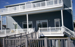 A gray house with a white railing.